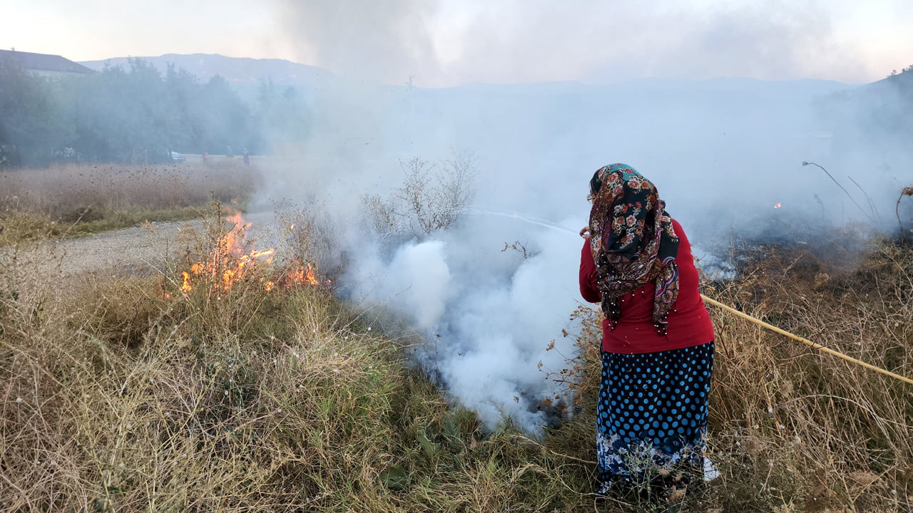 Karabük'te çıkan örtü yangınına mahalle sakinleri hortumla müdahale etti.