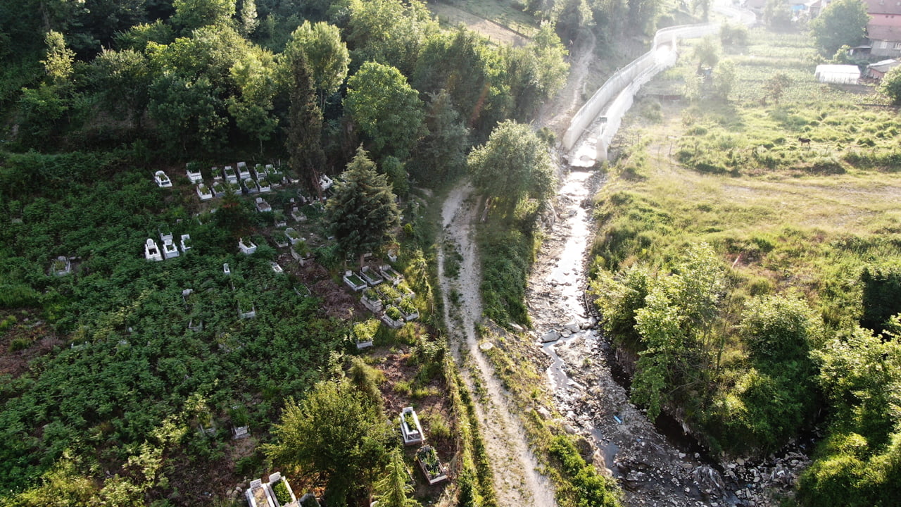 Karabük’ün Yenice ilçesine bağlı Değirmenyanı Köyü’nde dere ıslahı için çekilen istinat duvarının yarım bırakılması mezarlıklar için risk oluşturuyor.