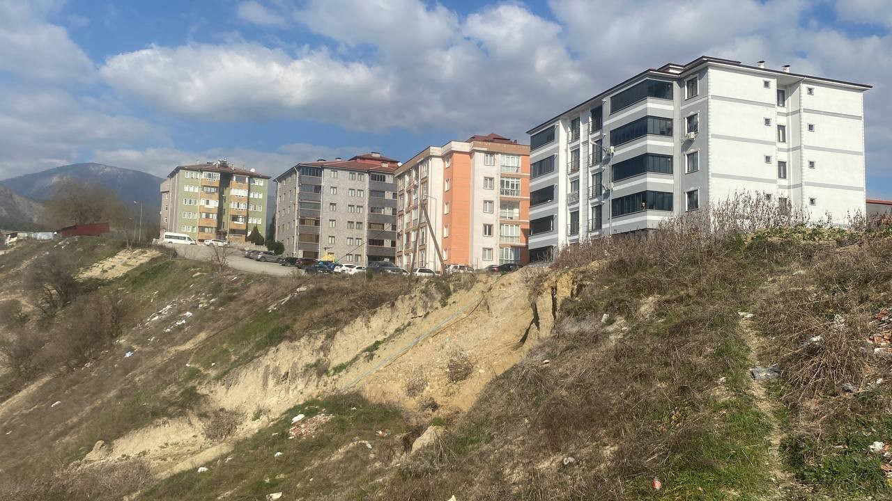 Karabük'te bir haddehaneye giden su borusunun patlaması sonrası meydana gelen toprak kayması, iki apartman için tehlike oluşturuyor.