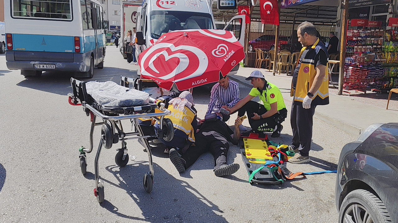 Karabük'te seyir halindeki motosikletin çarptığı vatandaş ile motosikletteki yolcu yaralandı. Yolda yatan yaralıyı, çevredeki esnaf güneşten şemsiye yardımı ile korudu.